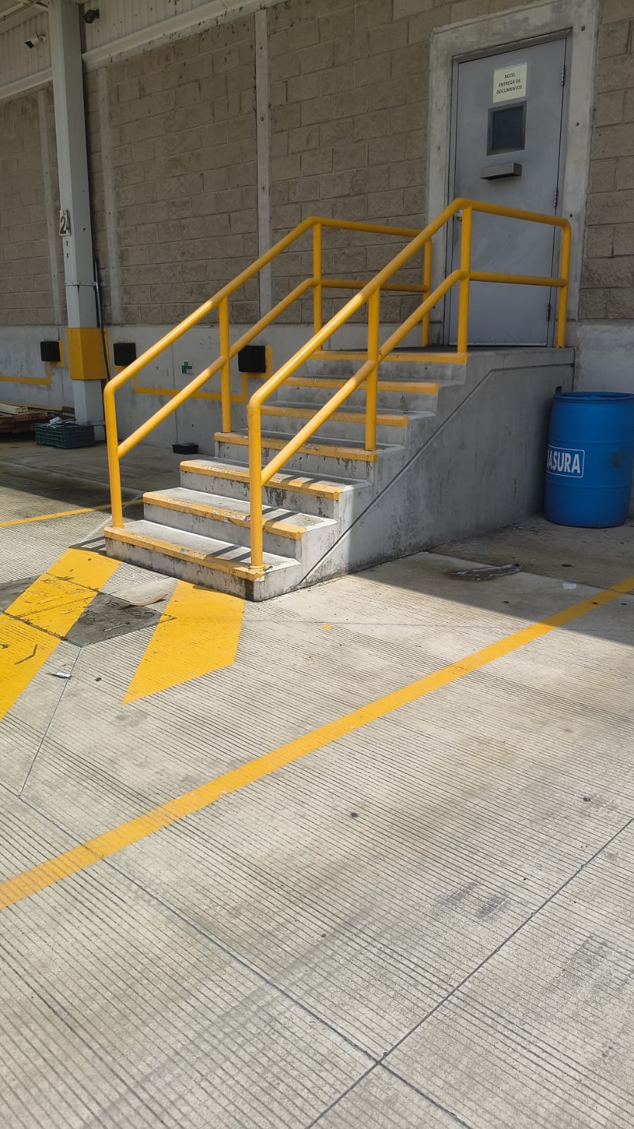 Escalera con barandal amarillo en andén de carga