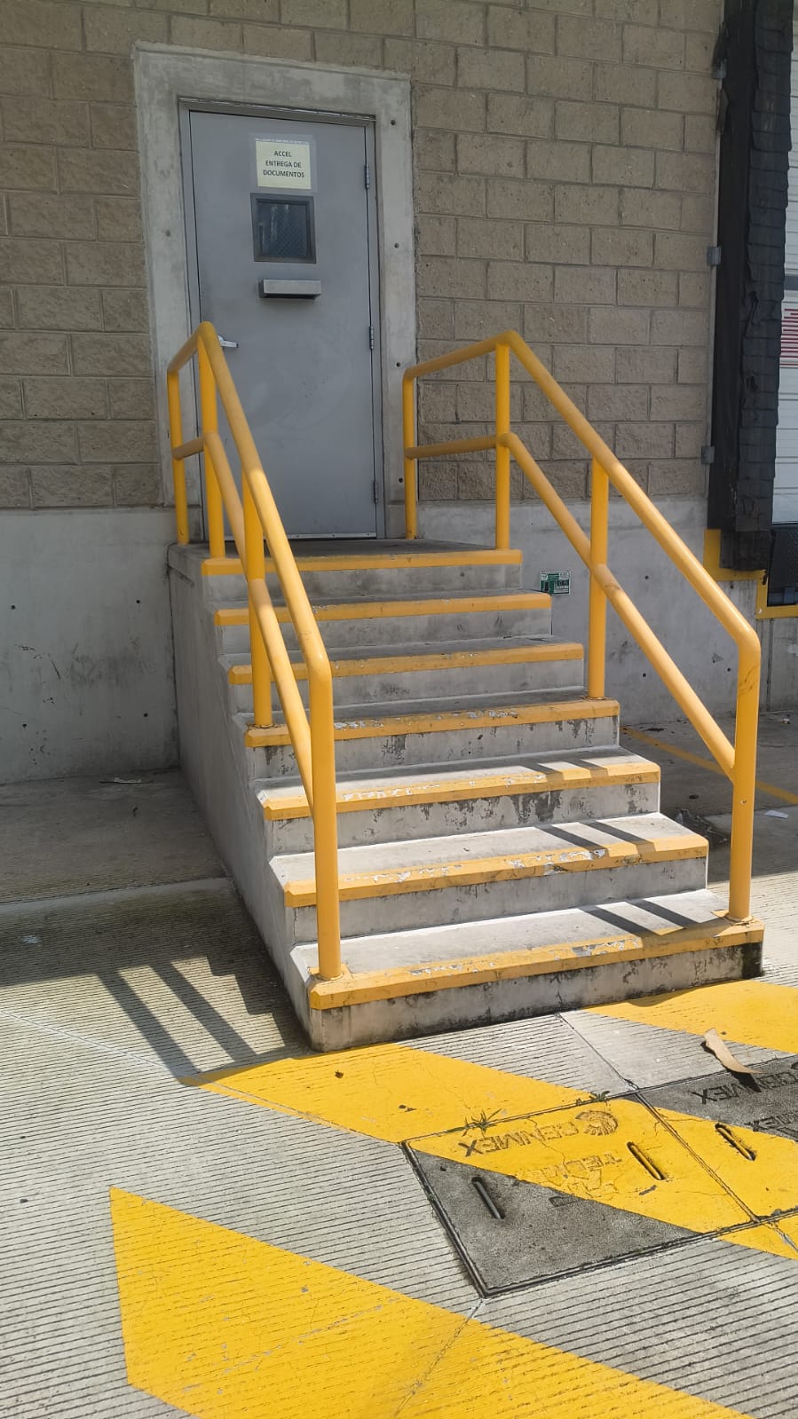 Barandal amarillo en escalera de andén